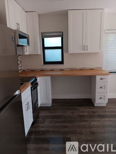 A kitchen with a wooden countertop and white cabinets.