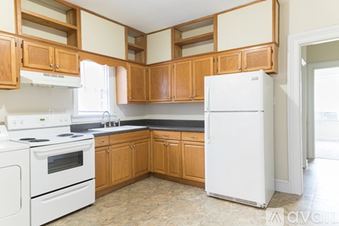 A kitchen with wooden cabinets and white appliances.