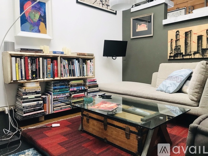 A living room with a couch, a coffee table, and a bookshelf filled with books.