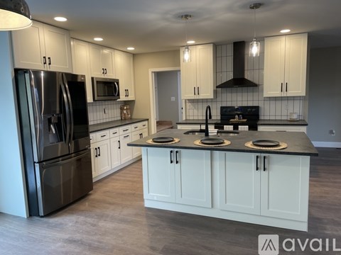 A modern kitchen with white cabinets and stainless steel appliances.