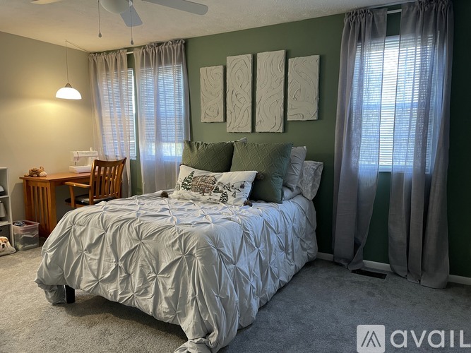 A bedroom with a large bed and a ceiling fan.
