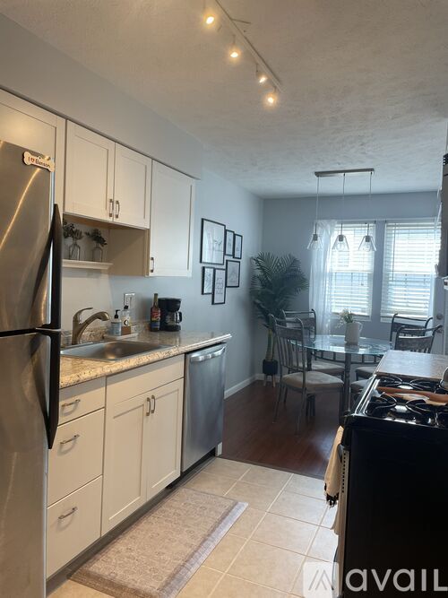 A kitchen with a stainless steel refrigerator and a black stove top oven.