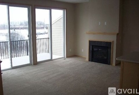 A living room with a fireplace and sliding glass doors.
