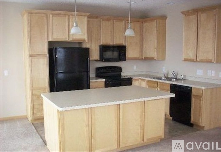 A kitchen with wooden cabinets and black appliances.