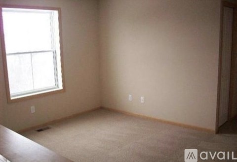 A room with a window and a door is available for rent.