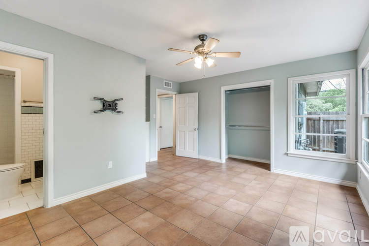 A living room with a ceiling fan and tile flooring.