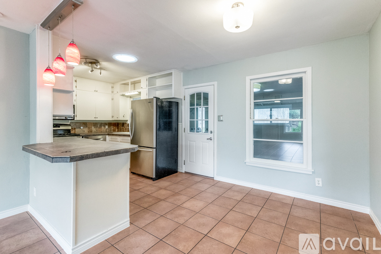 A kitchen with a refrigerator, sink, and cabinets.