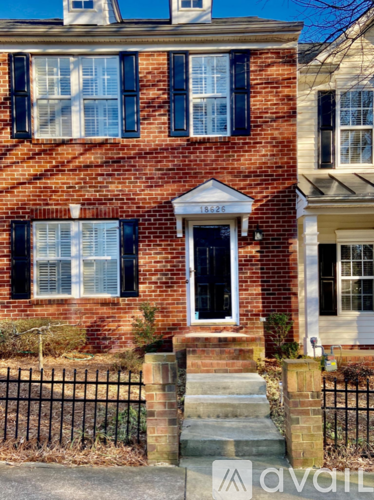 A red brick house with a black door and windows.