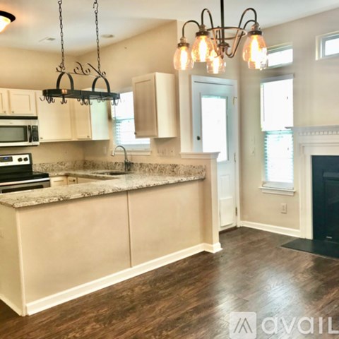 A kitchen with a granite countertop and a chandelier hanging from the ceiling.