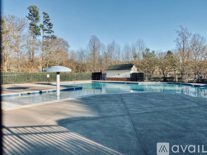 A pool surrounded by a fence with a building in the background.