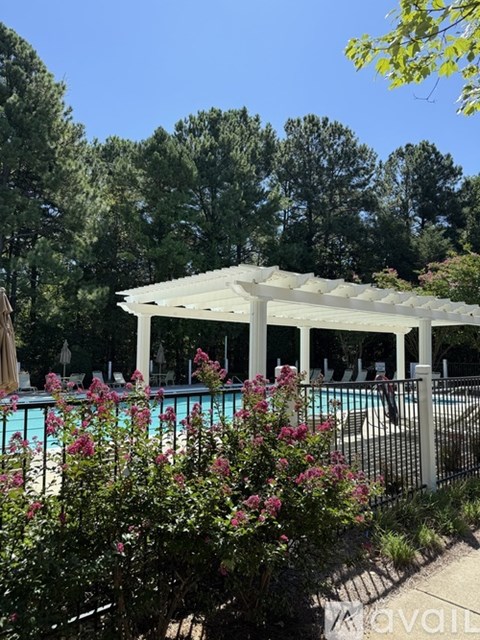 A pool area with a white canopy and a fence.
