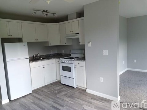A kitchen with white appliances and cabinets.