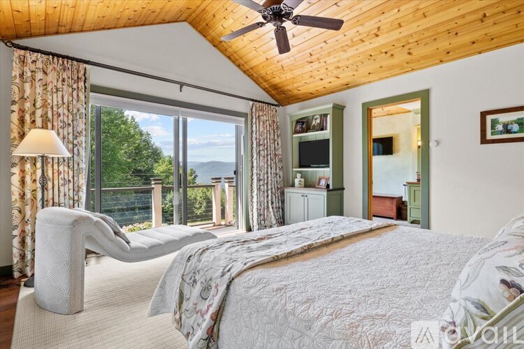 A bedroom with a large bed and a ceiling fan.