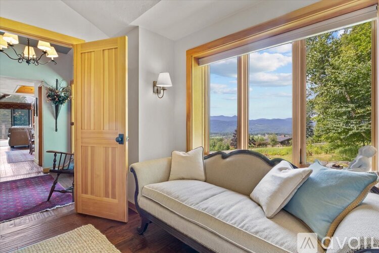 A living room with a couch and a view of the mountains.