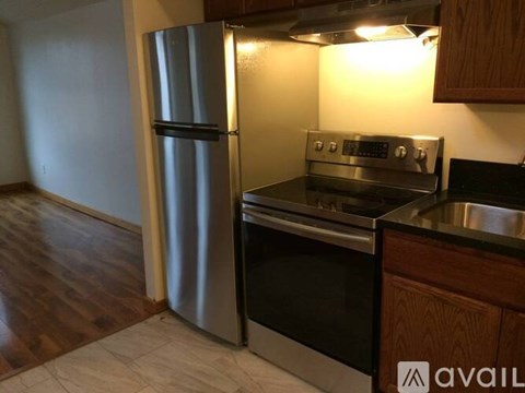 A modern kitchen with a stainless steel refrigerator and oven.