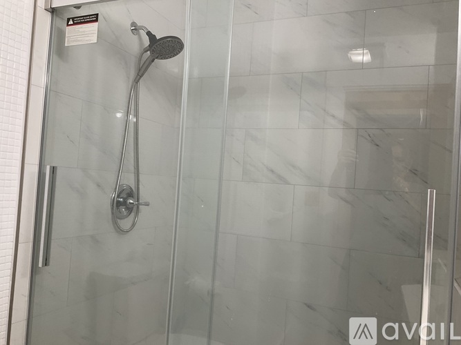 A shower with a glass door and a glass wall.