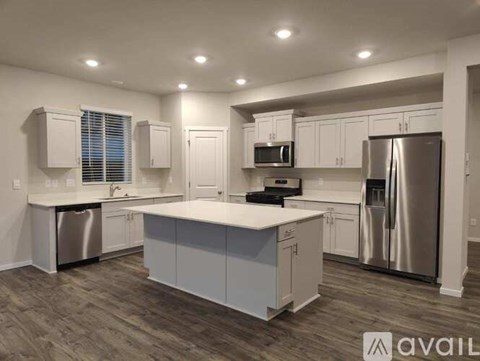 A modern kitchen with white cabinets and stainless steel appliances.