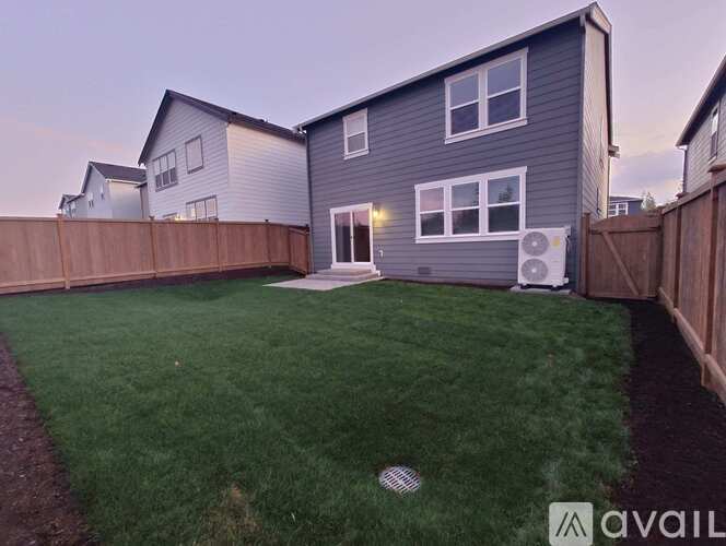 A house with a grey exterior and a green lawn.