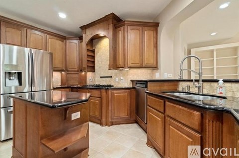 A kitchen with wooden cabinets and a black countertop.