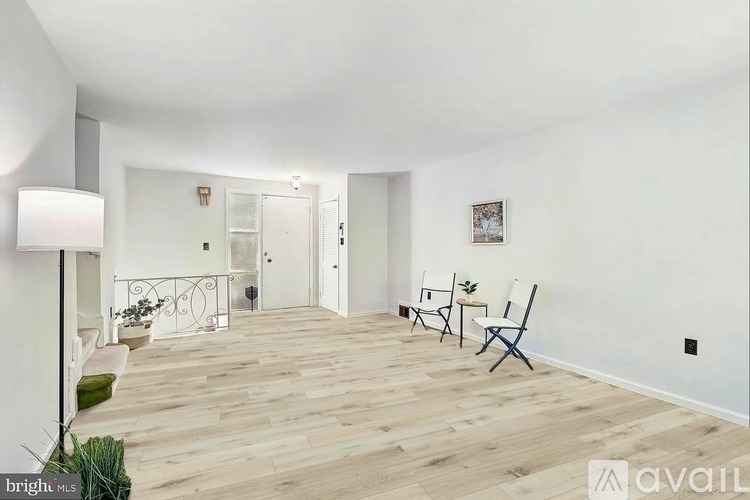 A bright living room with wooden floors and white walls.