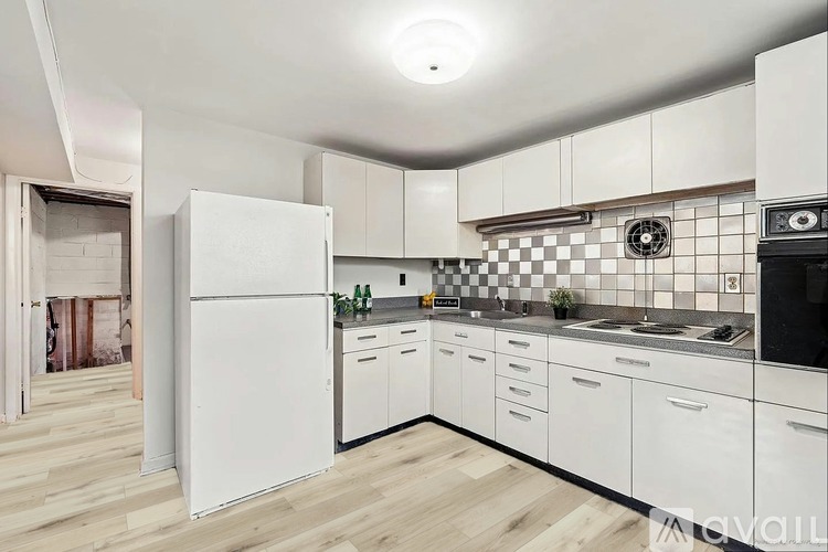A kitchen with white cabinets and a checkered backsplash.
