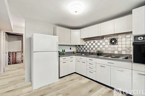 A kitchen with white cabinets and a checkered backsplash.