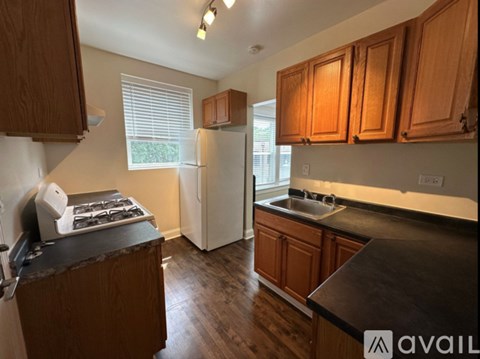 A kitchen with wooden cabinets and a black countertop.