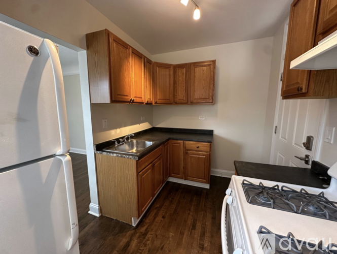 A kitchen with wooden cabinets and a white refrigerator.