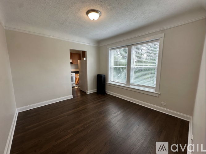 A room with wooden floors and a window with blinds.