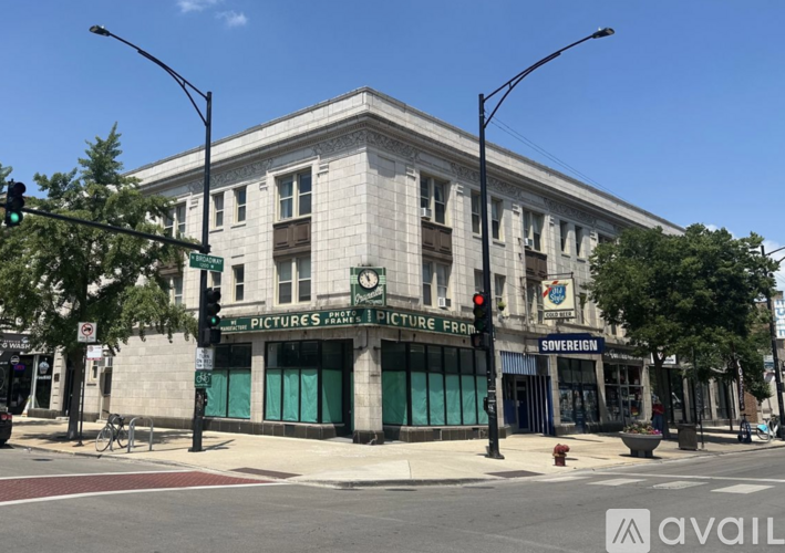 A street view of a building with a green awning that says "PICTURES".
