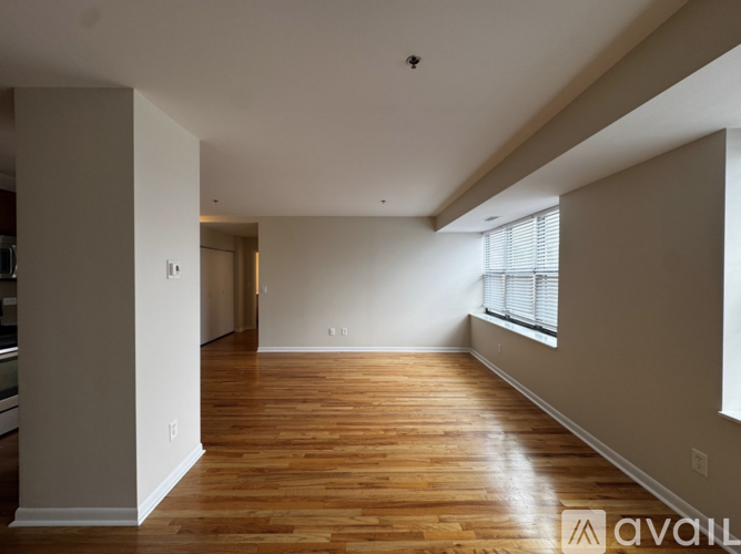 A spacious room with wooden floors and white walls.