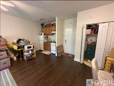 A kitchen with a white refrigerator and a white door is in the background.