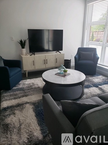 A living room with a television, two chairs, and a table.