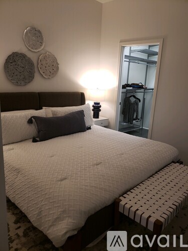 A bedroom with a large bed and a bench in front of it.