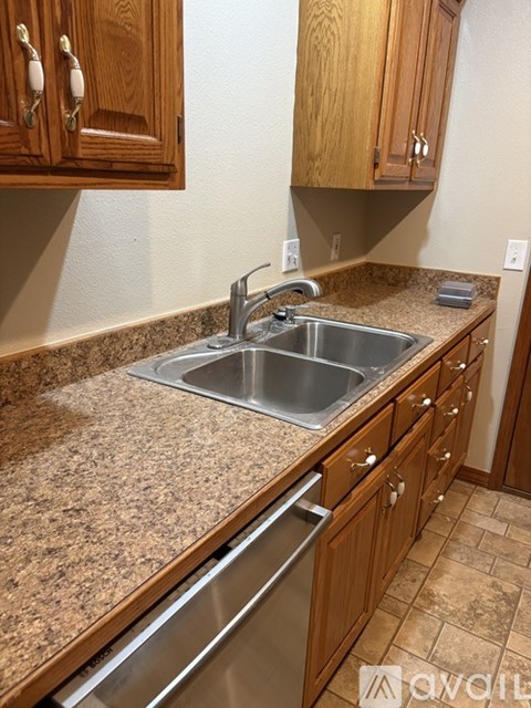 A kitchen with granite countertops and wooden cabinets.