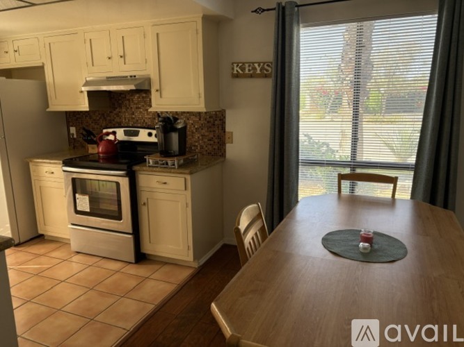 A kitchen with a table and chairs in front of a window.