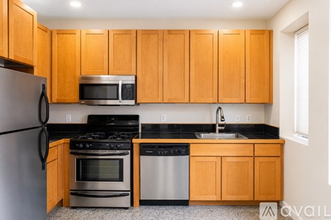 A kitchen with wooden cabinets and stainless steel appliances.