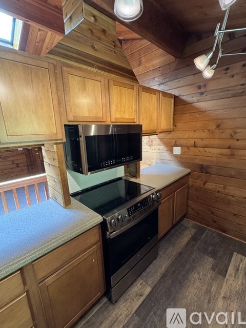 A kitchen with wooden cabinets and a black stove top oven.