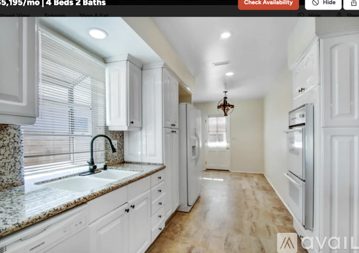 A kitchen with white cabinets and a granite countertop.