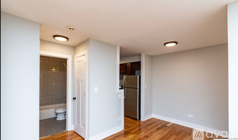 A kitchen with a refrigerator and a toilet in a room.