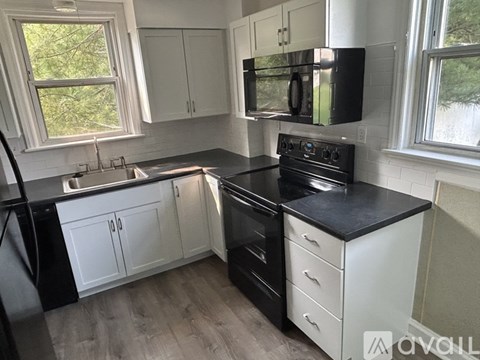 A kitchen with black and white appliances and cabinets.