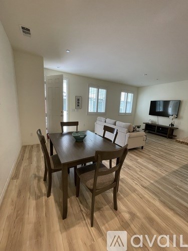 A dining room with a wooden table and chairs.