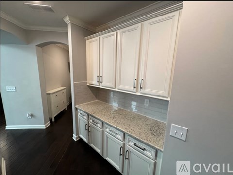 A kitchen with white cabinets and a granite countertop.