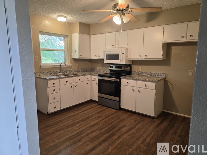A kitchen with white cabinets and a black stove top oven.