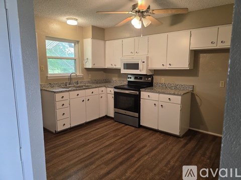 A kitchen with white cabinets and a black stove top oven.