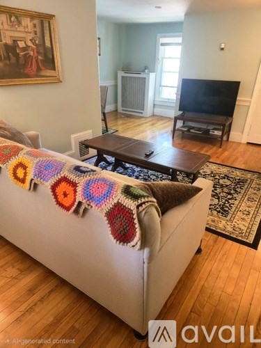 A living room with a couch, coffee table, and a painting on the wall.