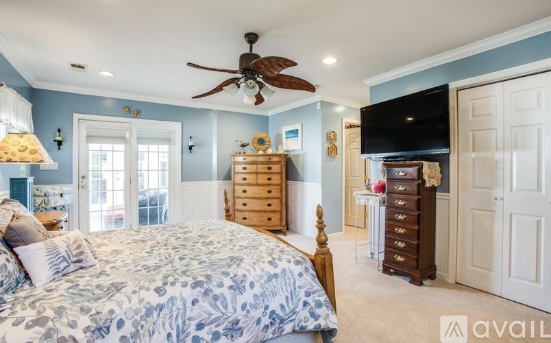A bedroom with a large bed and a ceiling fan.