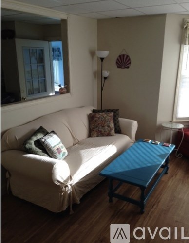 A living room with a white couch and a blue coffee table.