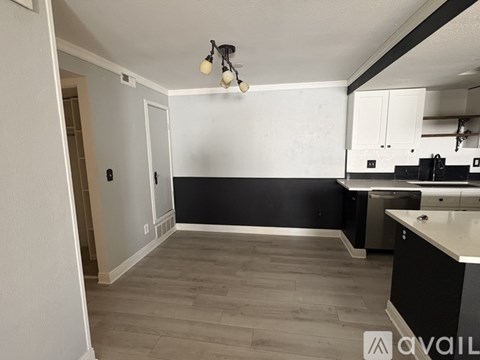 A kitchen with black walls and white cabinets.