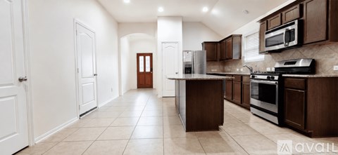 A kitchen with brown cabinets and a black stove top oven.